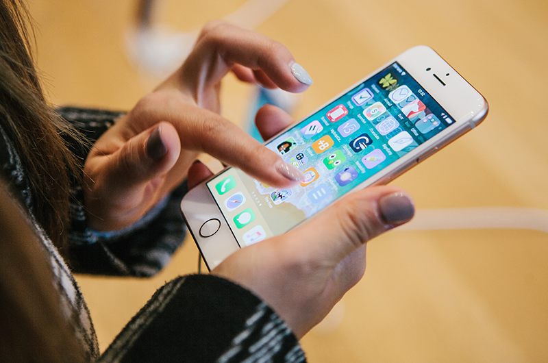 A girl holding iPhone 8 in her hand | LegalTechMunch