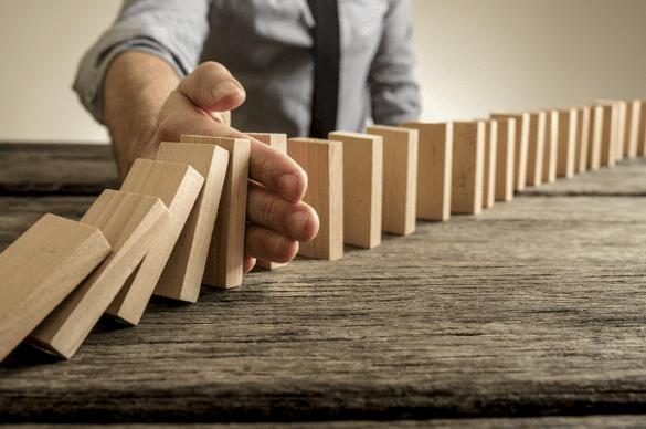 Man prevents blocks from falling representing Russia domino affect | LegalTechMunch