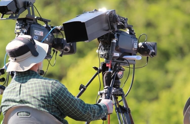 Cameraman with shooting equipment in a forest