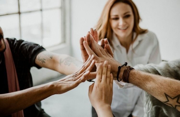 Group of diverse team joining hand in the middle