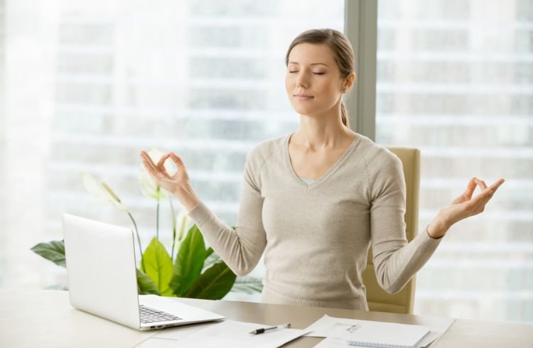 Calm businesswoman relaxing with breath gymnastics
