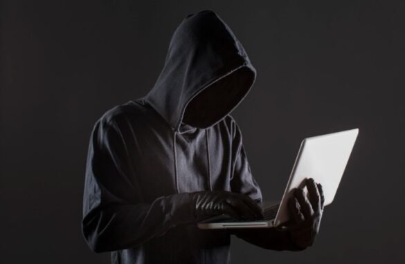 A cyber criminal using a laptop