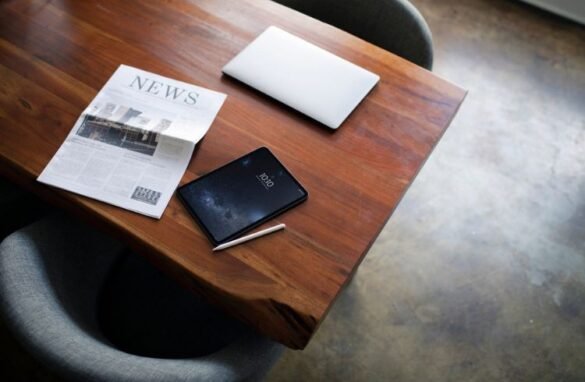 Newspaper on a table with a digital tablet