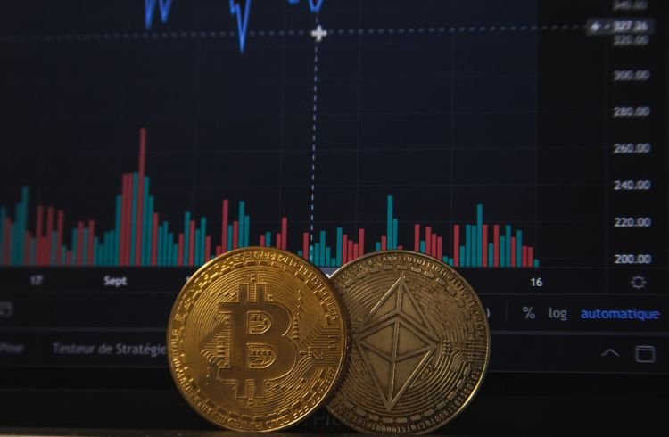 Bitcoin and Ethereum coins placed before a crypto market on a screen