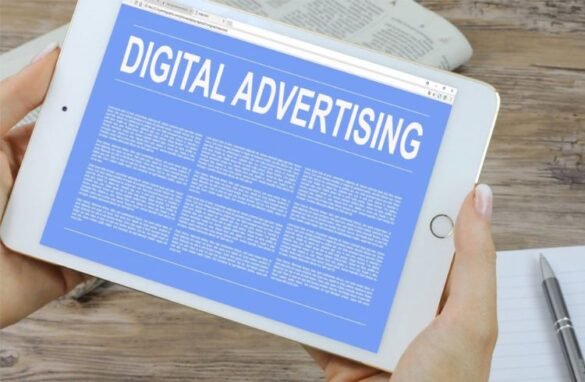 A picture of a woman holding a tablet with digital advertising written on the screen