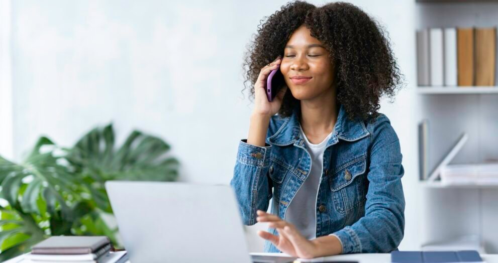 Attractive smiling African-American businesswoman chatting with customers at office