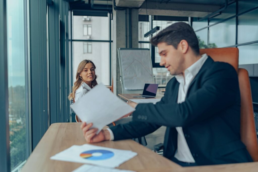 Mature businessman manager is holding legal documents consulting client at office meeting