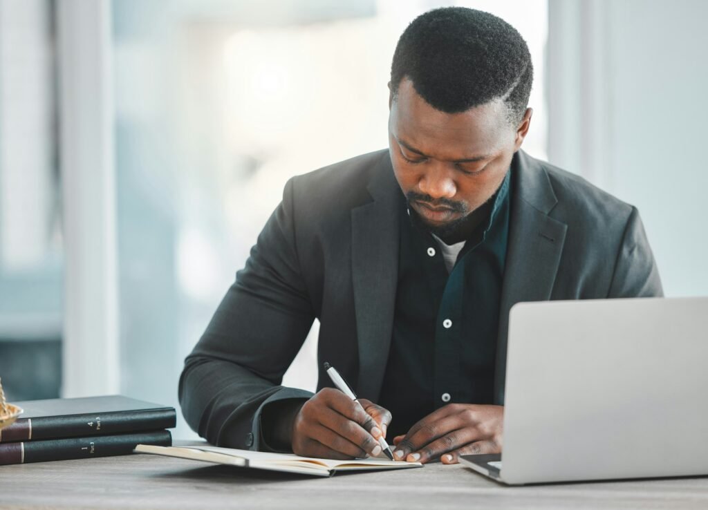 Writing, planning and man or lawyer at office desk with notes for legal research, ideas or brainsto