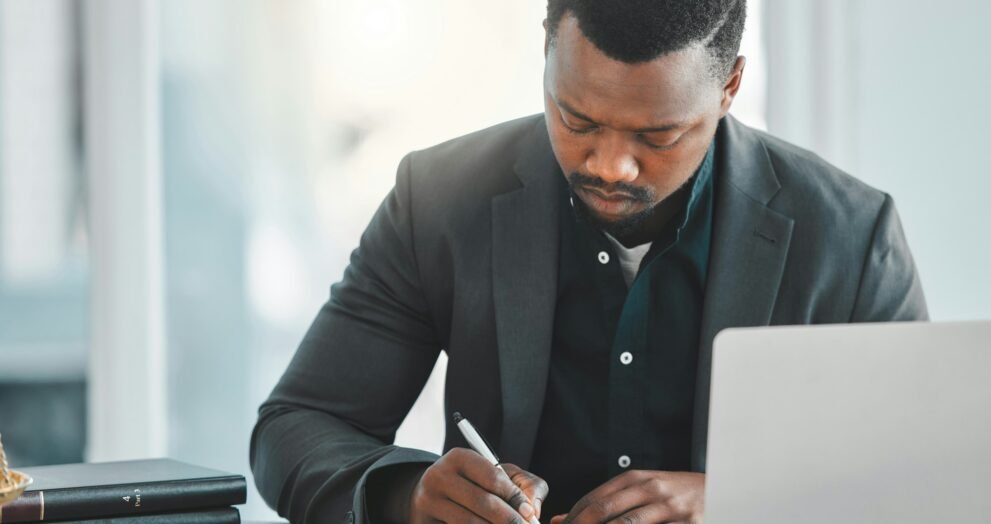 Writing, planning and man or lawyer at office desk with notes for legal research, ideas or brainsto